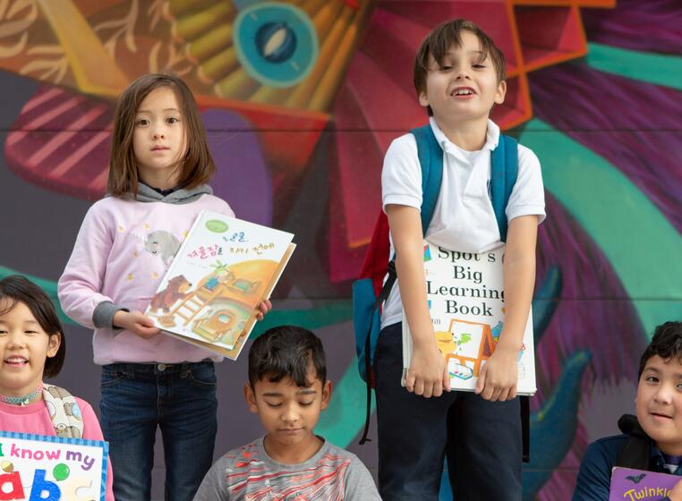 students holding books on the playground