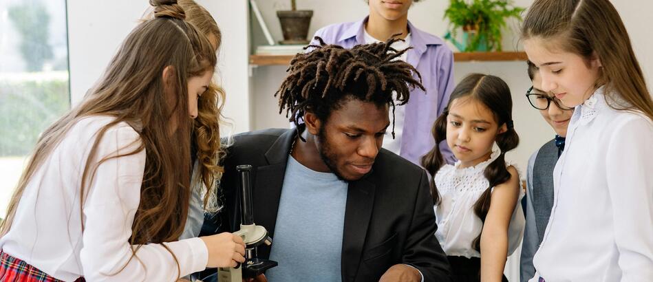 black teacher sitting with students